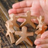business-success-concept-on-wooden-table-top-view-hands-protecting-woo